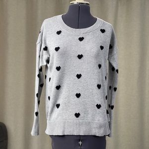 Grey sweater covered in black hearts